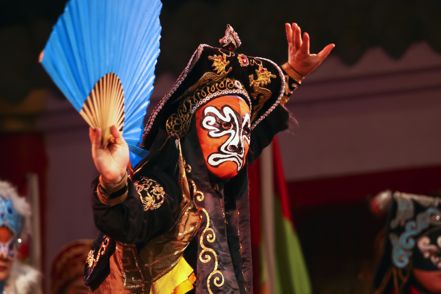 Masked magician performing Bian Lian tricks